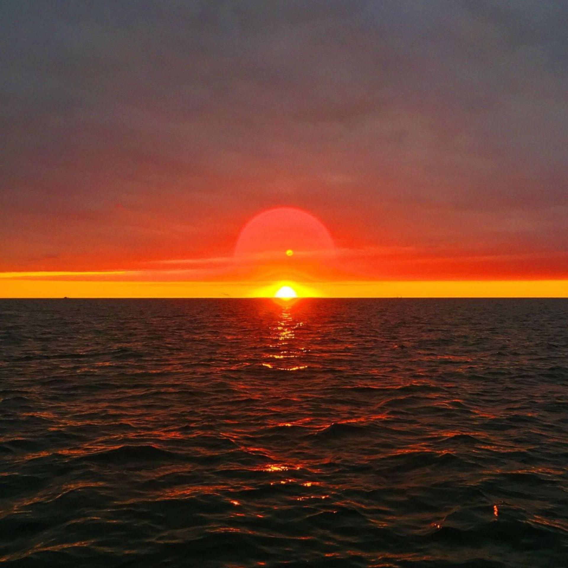 Два солнца на закате. Фото заходящего солнца на море.